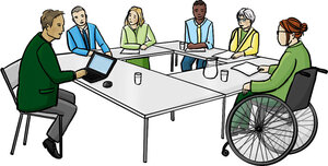 Viele Menschen sitzen an einem großen Tisch und unterhalten sich.
